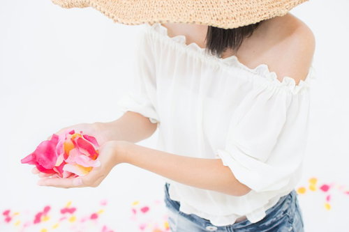 両手からこぼれるピンクの花びら、感謝と愛情を表現