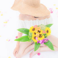 ひまわりのブーケを持つ女性の写真