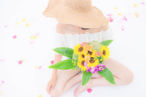 ひまわりのブーケを持つ女性
