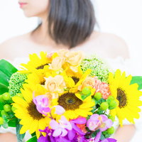 黄色いひまわりの手作りブーケを贈る女性の写真