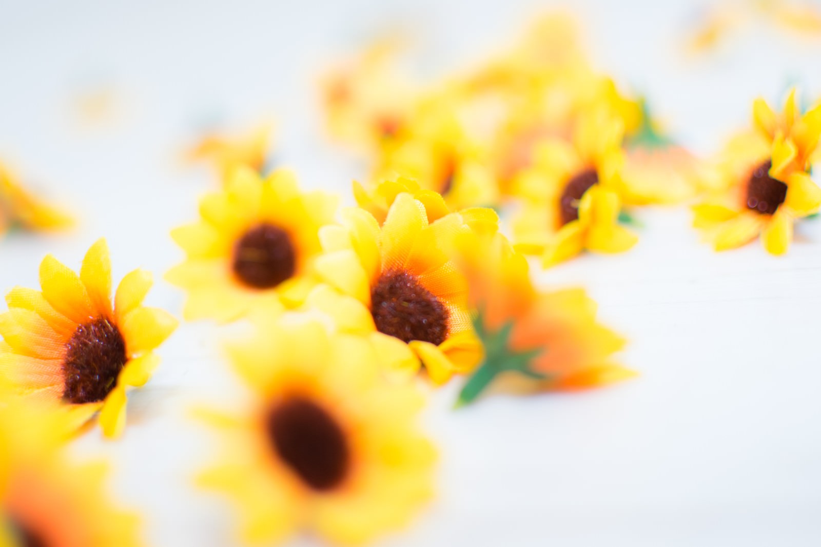 床に散らばる黄色いひまわり風の花のブローチ