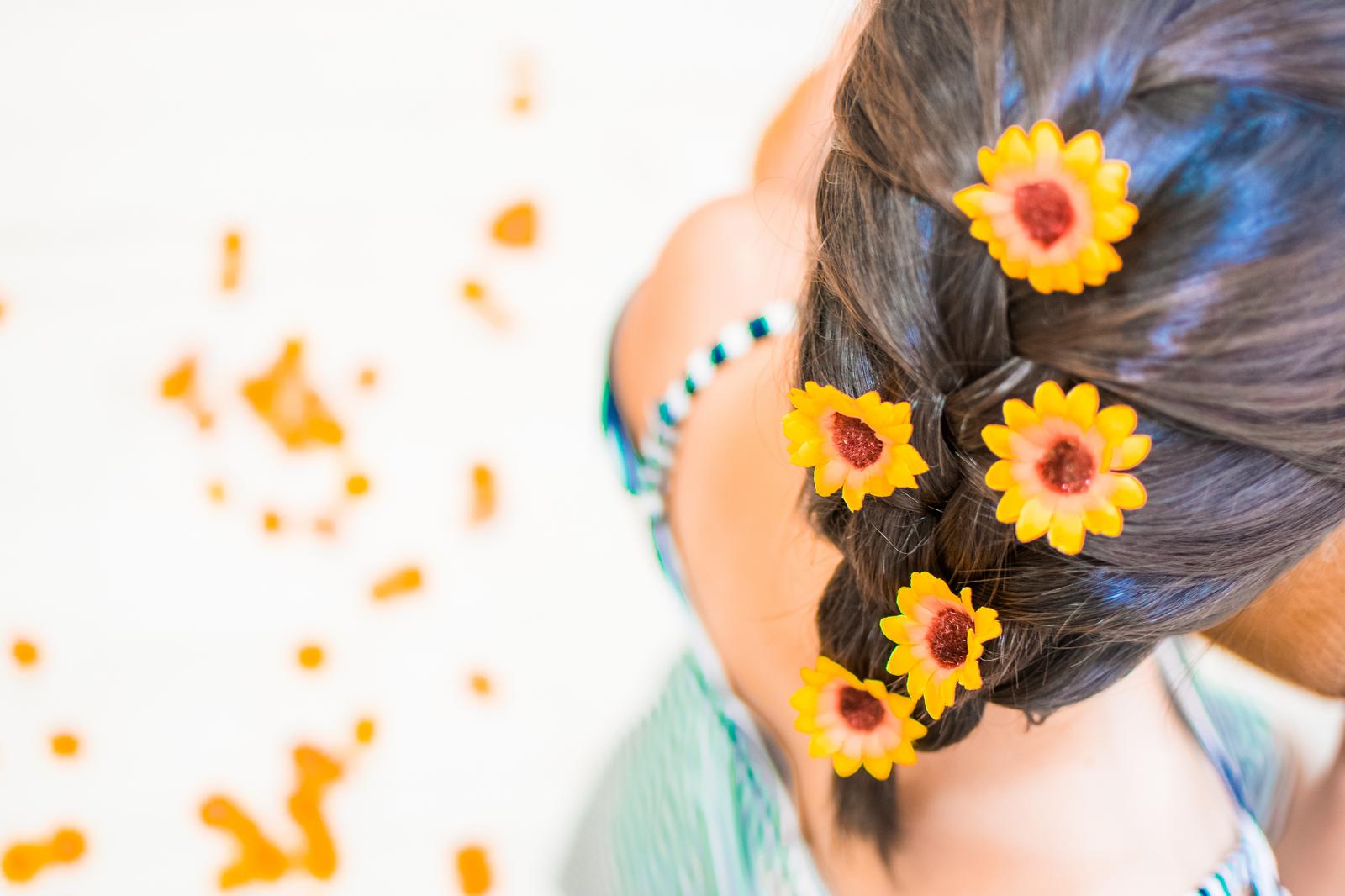 黒い長髪に黄色いひまわりの髪飾りが付いたヘアアレンジの後ろ姿