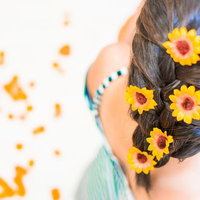 夏のひまわり髪飾りで彩る編み込みヘアアレンジの後ろ姿の写真