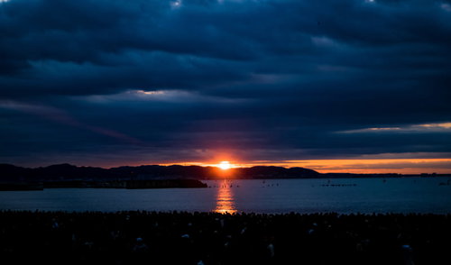雲間から見える初日の出と海面に映る光の道