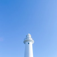 晴れた日の青空に白く映える灯台の写真