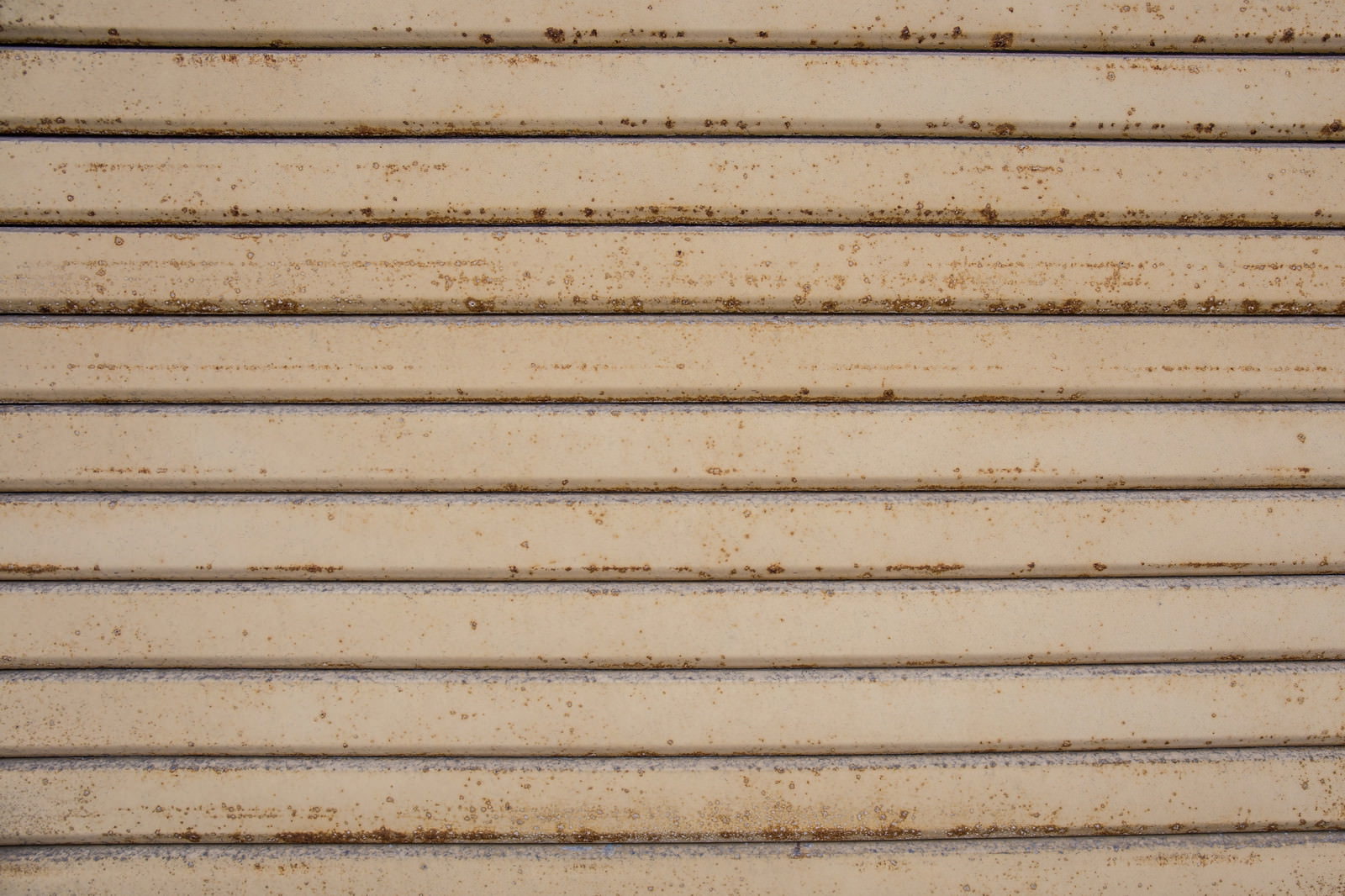 茶色い錆が浮き出た金属製シャッターの表面