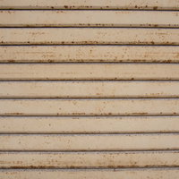 錆びかけてきた金属シャッターの表面の劣化テクスチャーの写真