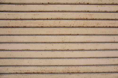 錆びかけてきた金属シャッターの表面の劣化テクスチャー