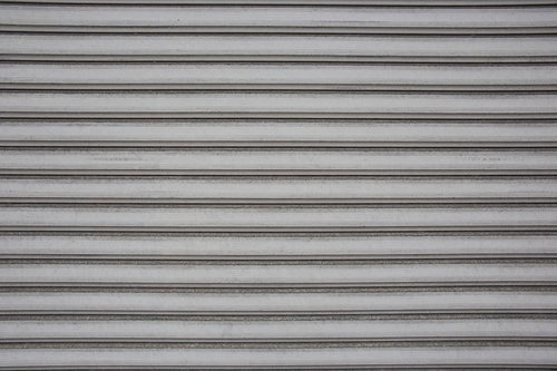 閉店後のグレーの金属製シャッターの店舗外観