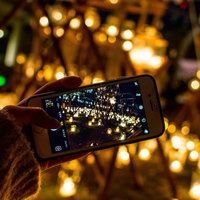 ライトアップされた光景をスマートフォンで撮影する手元の写真