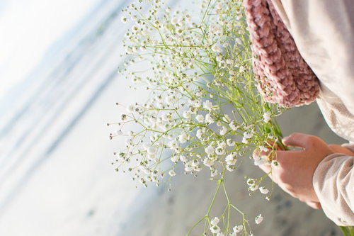 白いカスミソウを握る女性の手