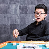 麻雀マナー：麻雀卓でくわえタバコをする男性の写真