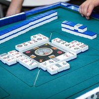 白熱の闘牌、集中して牌を打つ手元、雀卓での緊迫した対局風景の写真