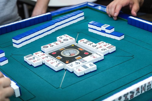 白熱の闘牌、集中して牌を打つ手元、雀卓での緊迫した対局風景