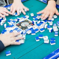 全自動卓で無意味の洗牌を繰り返す複数プレイヤーの手元の写真