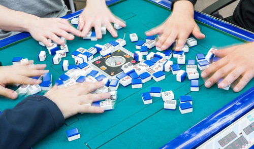 全自動卓で無意味の洗牌を繰り返す複数プレイヤーの手元