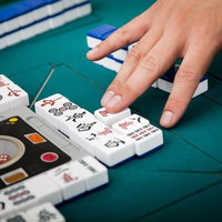 捨牌は6枚ごとに列を変更する麻雀卓での打牌風景の写真