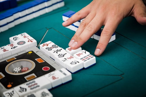 捨牌は6枚ごとに列を変更する麻雀卓での打牌風景