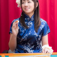 カンチャンをツモり、白い花飾りをつけた笑顔の女流雀士の写真