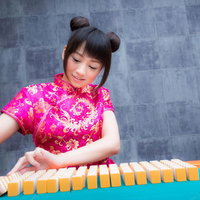 チャイナ服姿で麻雀卓を掃く女流雀士のプロ雀士の写真