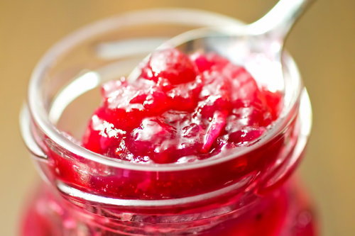 白い陶器のスプーンですくったいちごのジャム