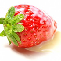 白い面に横たわる苺と周りに広がる練乳の写真