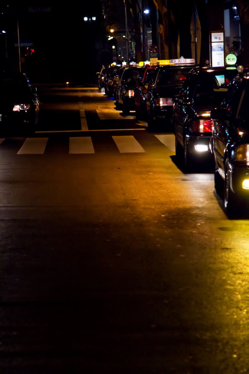 夜の道路で並ぶタクシーの列