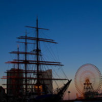 夕暮れの港に浮かぶみなとみらいの観覧車と帆船日本丸の写真