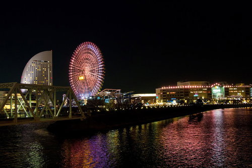 水面に光が映るみなとみらいの観覧車とワールドポーターズの夜景