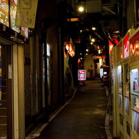 自動販売機と看板が灯る飲み屋の路地裏の夜の写真