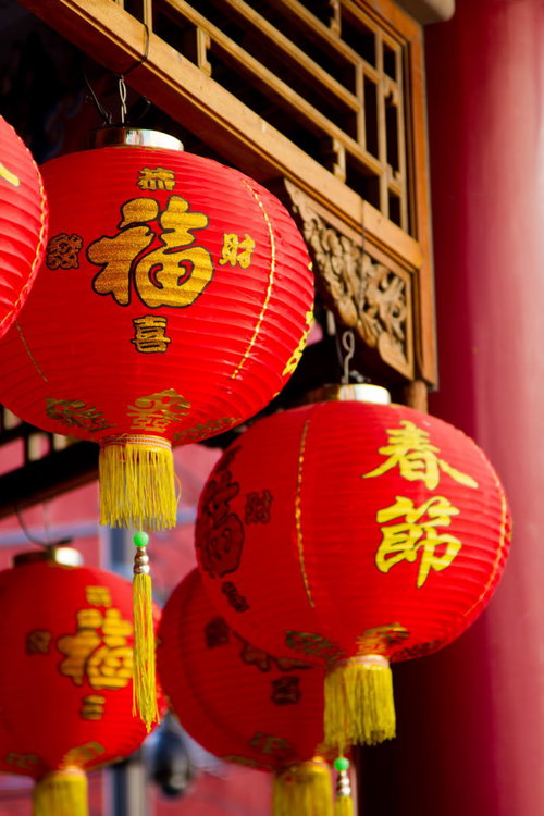 金色の文字と飾り房が付いた春節の赤い提灯