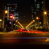車のテールランプが赤い光の筋になった新宿都庁前の大通りの夜景の写真