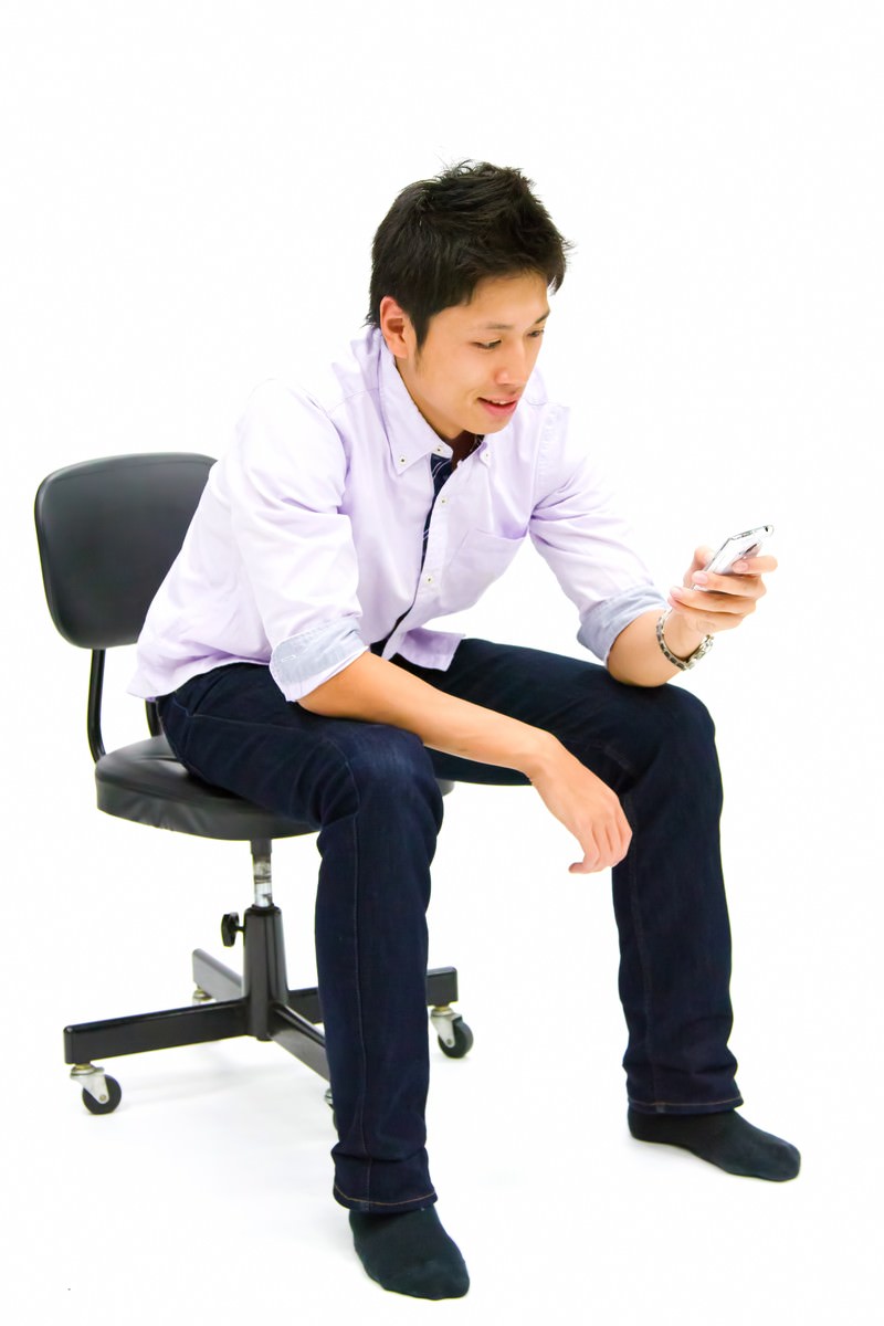 携帯を操作する青年［モデル：恭平］