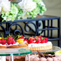 テーブルにきれいにセッティングされたケーキやマカロンの写真