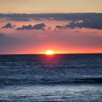 オレンジに染まる空と海のハワイ島サンセットの写真