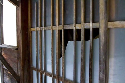 自然光が差し込む木製格子柵の割られたガラス戸