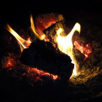 赤く熱した炭と立ち上る暖炉の火の写真