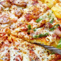 チーズとトッピングがたっぷり載った出来立てピザの写真