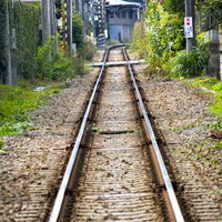 住宅地の中をまっすぐ続く江ノ電の線路の写真