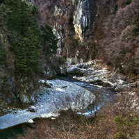 白い岩壁がそびえる冬の鬼怒川楯岩の渓谷の写真