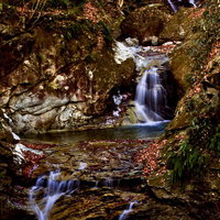 苔むした岩間を流れ落ちる鬼怒川古釜の滝の写真