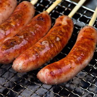 網の上で焼き色がつくジューシーなフランクフルトの写真