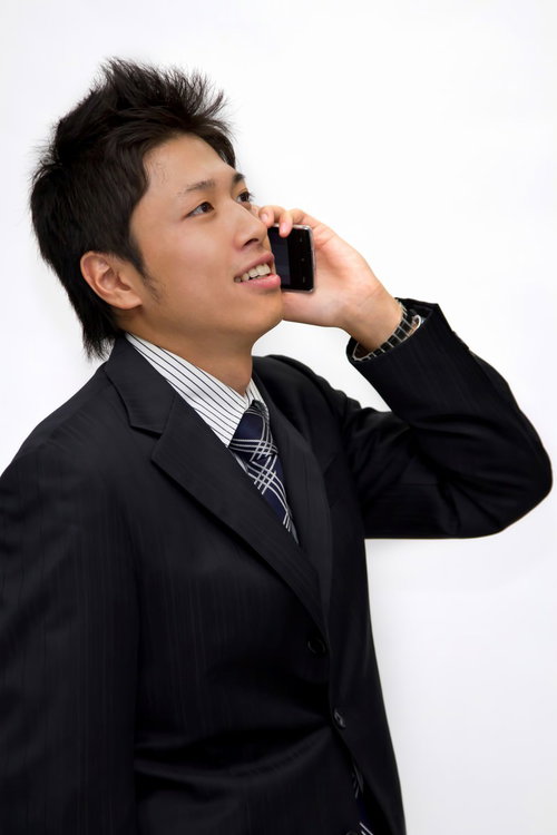 携帯電話を耳に当てて話し中のサラリーマン