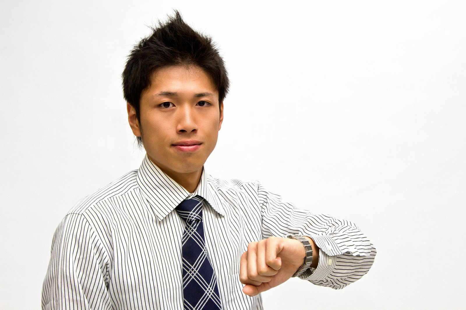 腕時計を見るネクタイ姿の男性［モデル：恭平］