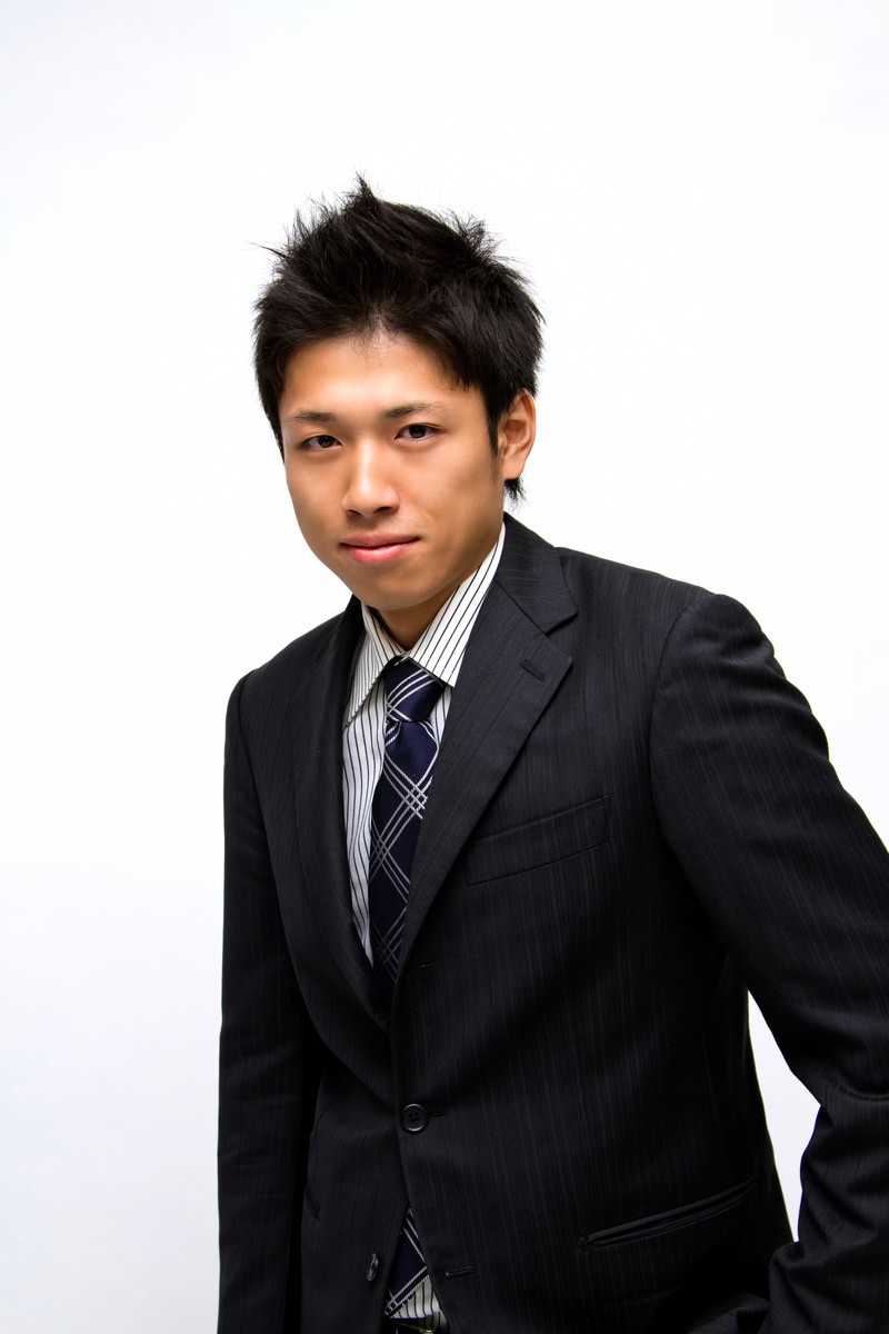 Young man in black suit looking at camera