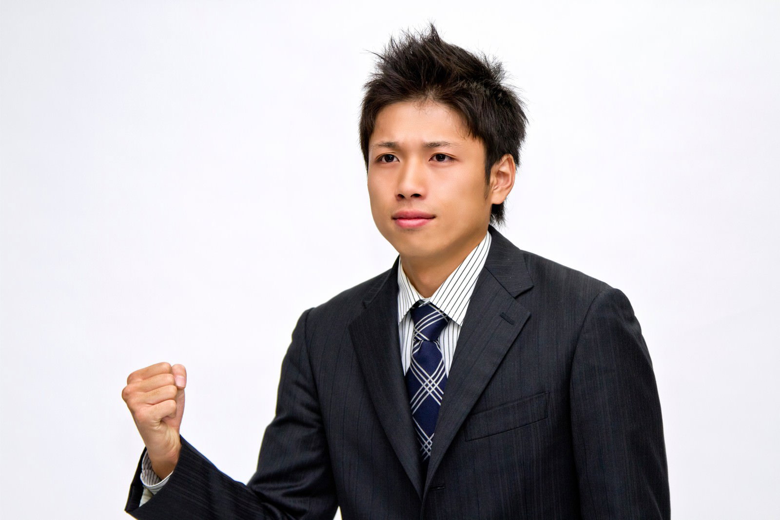 拳を握るスーツ姿のビジネスマン［モデル：恭平］