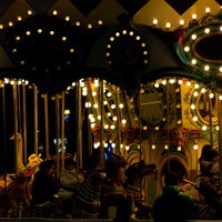 暗い夜空に色とりどりの電球で照らされたメリーゴーランドの写真