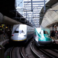ホームに並んで停車中の新幹線はやぶさと白い車両の写真
