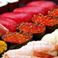 手前のイクラにピントが合った寿司詰め合わせの写真