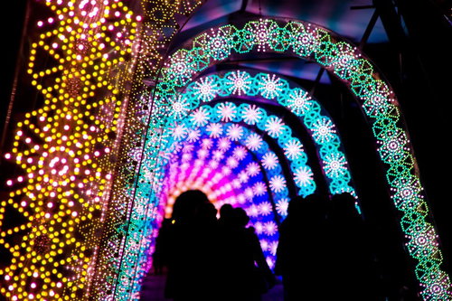 虹色のイルミネーショントンネルの中のライトアップされた道